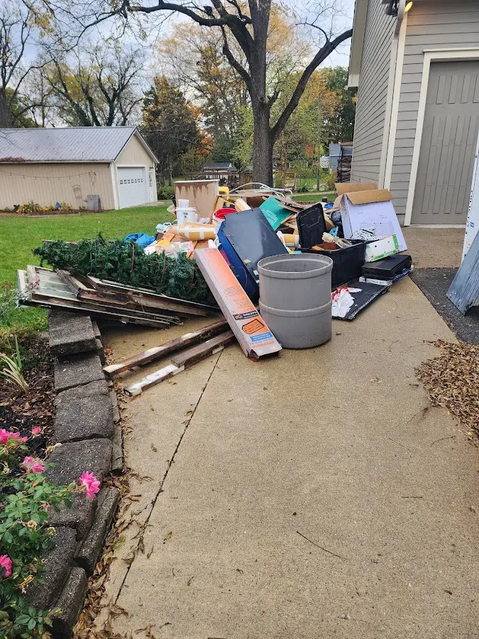 Dumpster being loaded with debris for Estate Cleanout Dumpster Rental in Pelican Bay